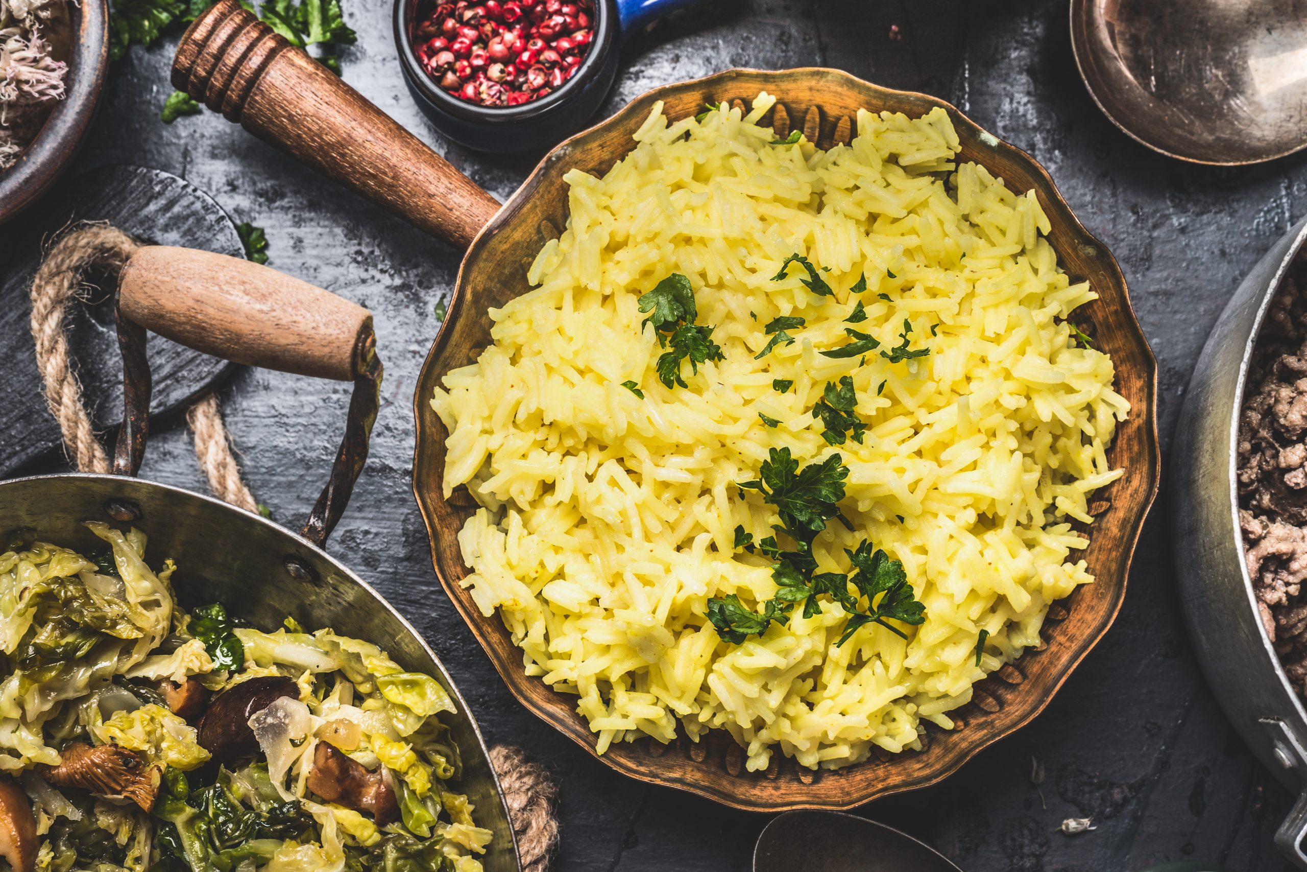 easy yellow rice flavored with saffron in cooking pan on rustic background, top view