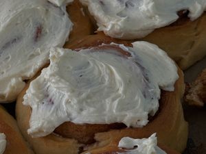 Photo by Aljona Ovtšinnikova Close-up of freshly baked cinnamon rolls topped with creamy cream cheese frosting.